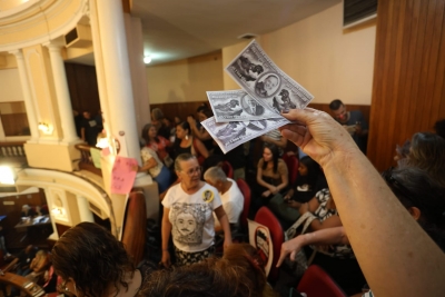 Manifestante exibe cédulas simbólicas de dinheiro para vereadores em Niterói